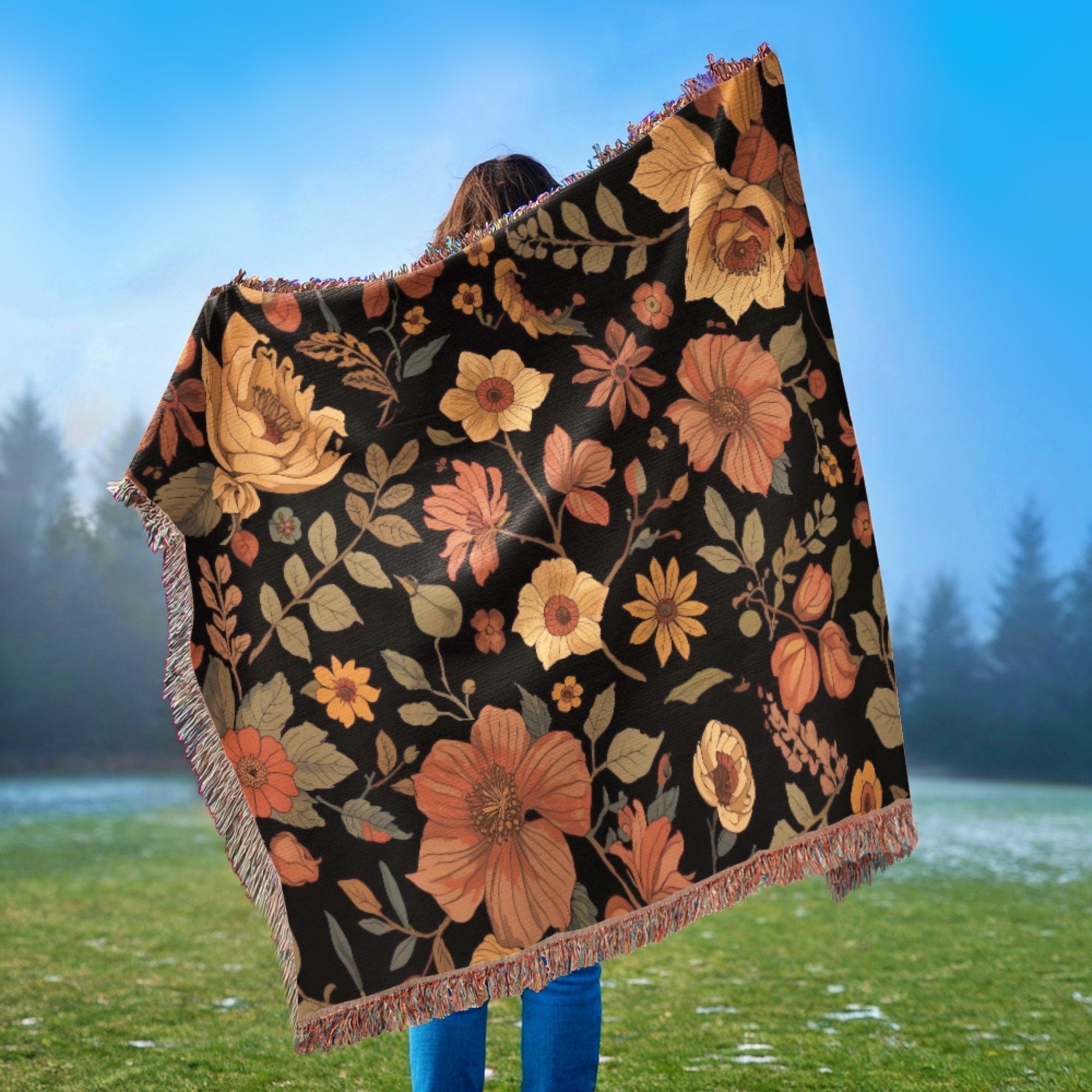Person holding a William Morris style fall floral blanket with a black background in an outdoor setting.