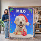 Two people holding a blanket with a dog wearing a Santa hat and the name 'Milo'.